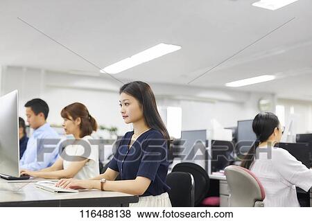 Stock Photo - Japanese woman working in the office. Fotosearch