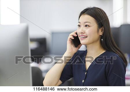 Stock Photograph - Japanese woman working in the office. Fotosearch