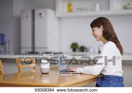 Picture - Japanese woman working remotely. Fotosearch