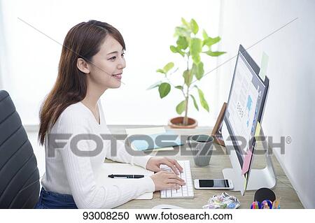 Stock Image - Japanese woman working remotely. Fotosearch