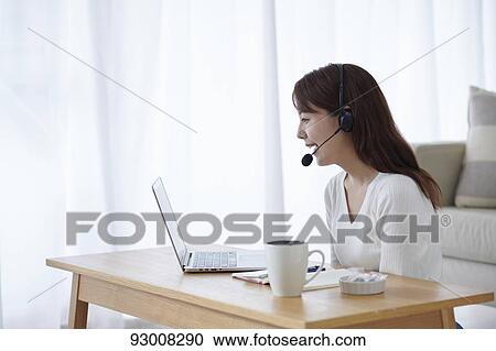 Stock Image - Japanese woman working remotely. Fotosearch