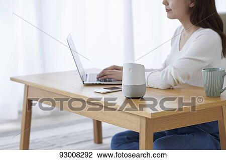 Stock Image - Japanese woman working remotely. Fotosearch