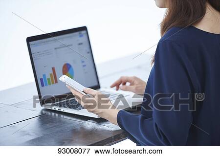 Stock Photo - Japanese woman working remotely. Fotosearch