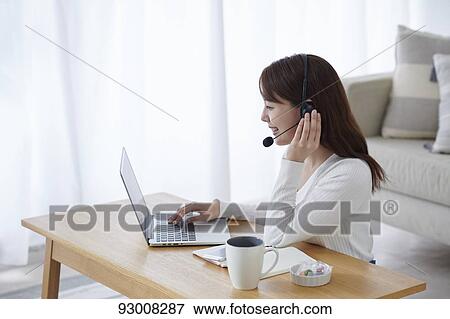 Stock Photo - Japanese woman working remotely. Fotosearch