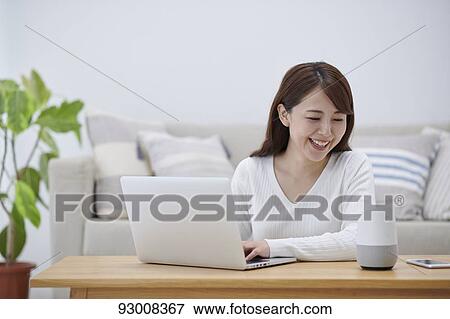 Stock Photo - Japanese woman working remotely. Fotosearch