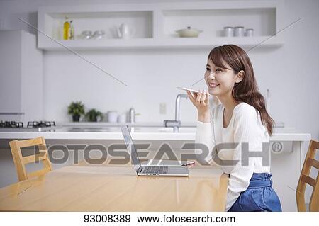 Stock Photo - Japanese woman working remotely. Fotosearch
