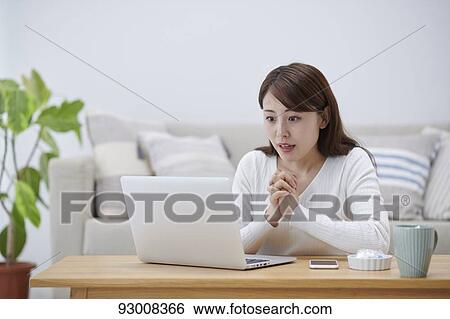 Stock Photograph - Japanese woman working remotely. Fotosearch