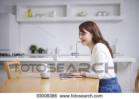 Stock Photograph - Japanese woman working remotely. Fotosearch