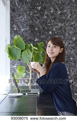 Stock Photography - Japanese woman working remotely. Fotosearch