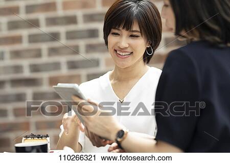 Stock Image - Japanese women at a cafe. Fotosearch
