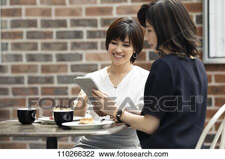 Stock Image - Japanese women at a cafe. Fotosearch