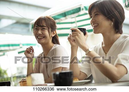 Stock Photograph - Japanese women at a cafe. Fotosearch