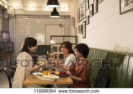 Picture - Japanese women happily dining together. Fotosearch