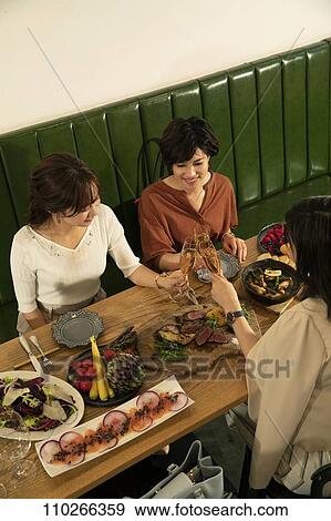 Stock Photo - Japanese women happily dining together. Fotosearch
