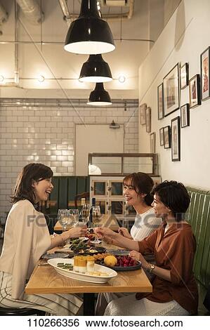 Stock Photograph - Japanese women happily dining together. Fotosearch