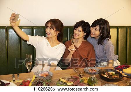 Stock Photography - Japanese women happily dining together. Fotosearch
