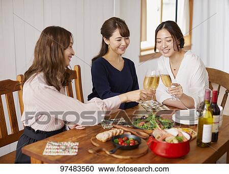 Stock Image - Japanese women having home party. Fotosearch