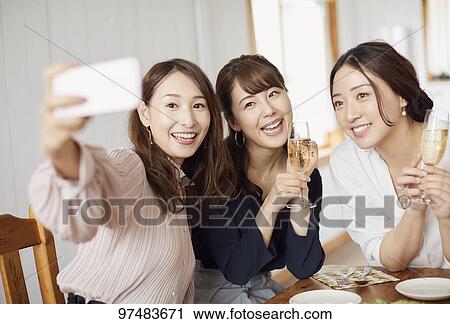 Stock Image - Japanese women having home party. Fotosearch