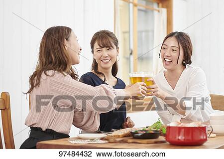 Stock Image - Japanese women having home party. Fotosearch