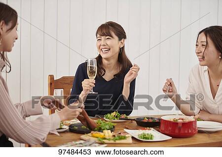 Stock Image - Japanese women having home party. Fotosearch