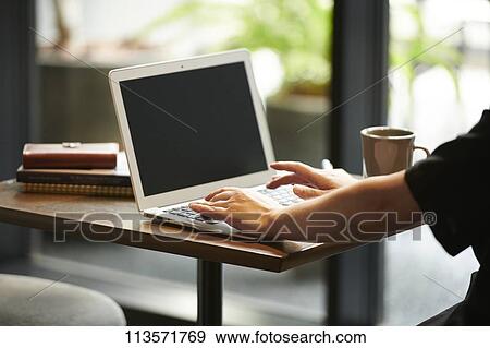 Man using laptop at a cafe View Large Photo Image Stock Photo - Man using laptop at a cafe. Fotosearch