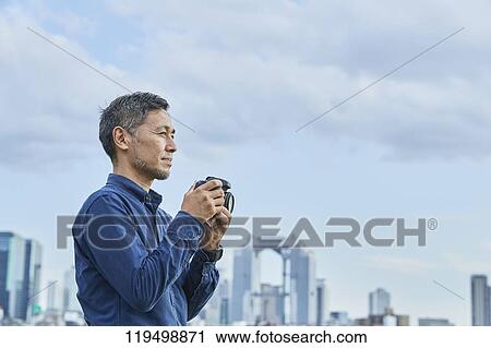 Stock Image - Mature Japanese man downtown Osaka, Japan. Fotosearch