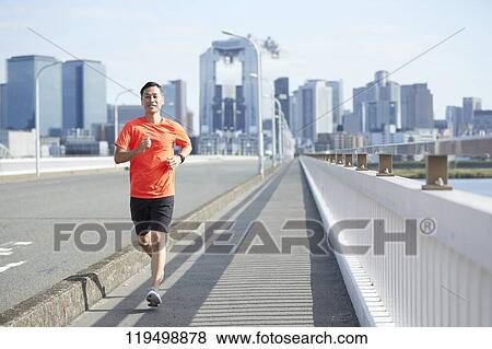 Stock Photo - Mature Japanese man running downtown Osaka, Japan. Fotosearch