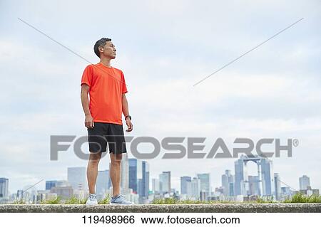 Stock Photograph - Mature Japanese man running downtown Osaka, Japan. Fotosearch