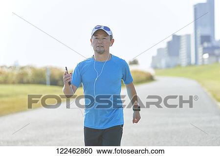 Stock Image - Mature Japanese man training downtown. Fotosearch