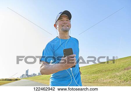 Stock Image - Mature Japanese man training downtown. Fotosearch