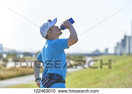 Stock Image - Mature Japanese man training downtown. Fotosearch