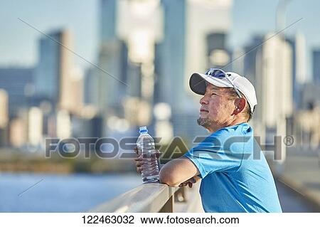 Stock Image - Mature Japanese man training downtown. Fotosearch