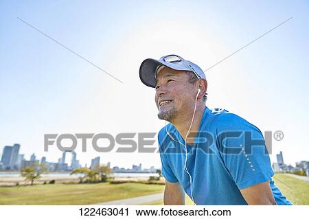 Stock Image - Mature Japanese man training downtown. Fotosearch