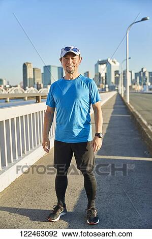Stock Image - Mature Japanese man training downtown. Fotosearch