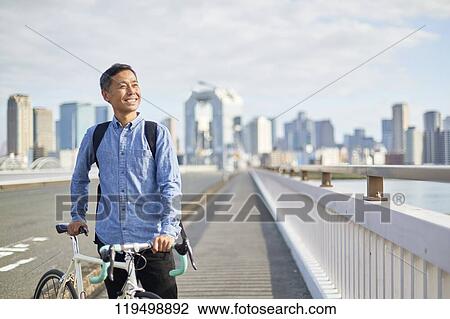 Mature Japanese man with bike downtown Osaka, Japan View Large Photo Image Stock Image - Mature Japanese man with bike downtown Osaka, Japan. Fotosearch