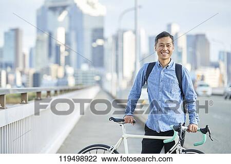 Mature Japanese man with bike downtown Osaka, Japan View Large Photo Image Stock Image - Mature Japanese man with bike downtown Osaka, Japan. Fotosearch