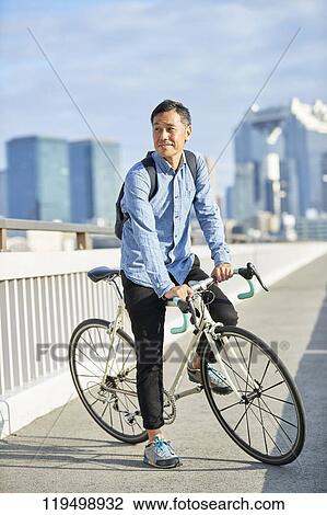 Mature Japanese man with bike downtown Osaka, Japan View Large Photo Image Stock Image - Mature Japanese man with bike downtown Osaka, Japan. Fotosearch