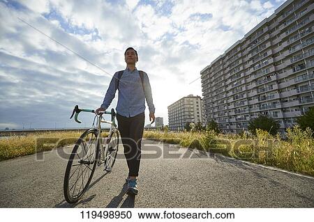 Mature Japanese man with bike downtown Osaka, Japan View Large Photo Image Stock Image - Mature Japanese man with bike downtown Osaka, Japan. Fotosearch