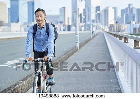Mature Japanese man with bike downtown Osaka, Japan View Large Photo Image Stock Photo - Mature Japanese man with bike downtown Osaka, Japan. Fotosearch