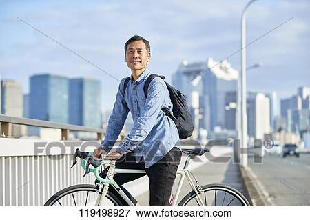 Mature Japanese man with bike downtown Osaka, Japan View Large Photo Image Stock Photo - Mature Japanese man with bike downtown Osaka, Japan. Fotosearch