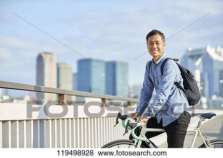 Mature Japanese man with bike downtown Osaka, Japan View Large Photo Image Stock Photo - Mature Japanese man with bike downtown Osaka, Japan. Fotosearch