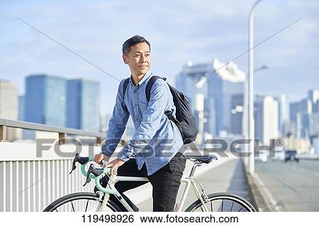 Mature Japanese man with bike downtown Osaka, Japan View Large Photo Image Stock Photograph - Mature Japanese man with bike downtown Osaka, Japan. Fotosearch