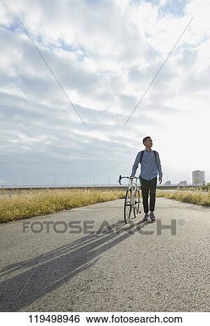 Mature Japanese man with bike downtown Osaka, Japan View Large Photo Image Stock Photograph - Mature Japanese man with bike downtown Osaka, Japan. Fotosearch