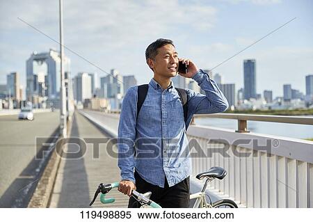 Mature Japanese man with bike downtown Osaka, Japan View Large Photo Image Stock Photography - Mature Japanese man with bike downtown Osaka, Japan. Fotosearch