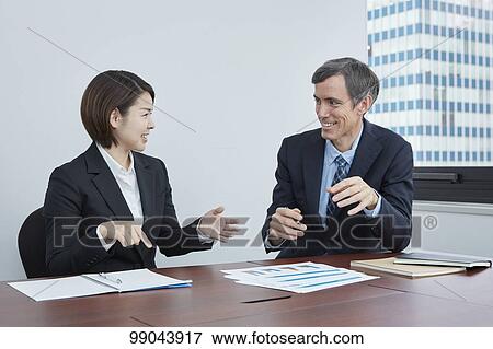 Stock Photo - Multi-ethnic business people having meeting. Fotosearch