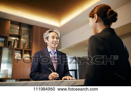 Senior businessman checking in at hotel View Large Photo Image Stock Image - Senior businessman checking in at hotel. Fotosearch