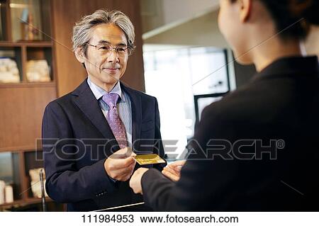 Stock Image - Senior businessman checking in at hotel. Fotosearch