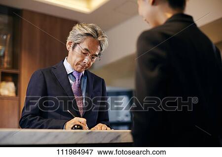 Senior businessman checking in at hotel View Large Photo Image Stock Photo - Senior businessman checking in at hotel. Fotosearch