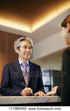 Senior businessman checking in at hotel View Large Photo Image Stock Photo - Senior businessman checking in at hotel. Fotosearch