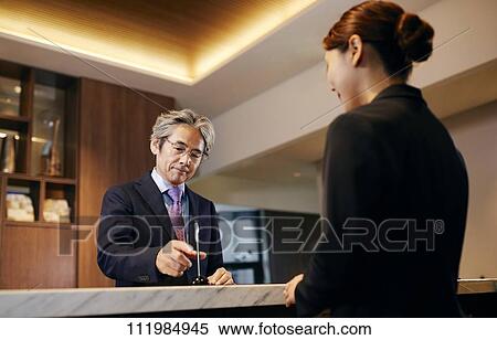 Senior businessman checking in at hotel View Large Photo Image Stock Photography - Senior businessman checking in at hotel. Fotosearch